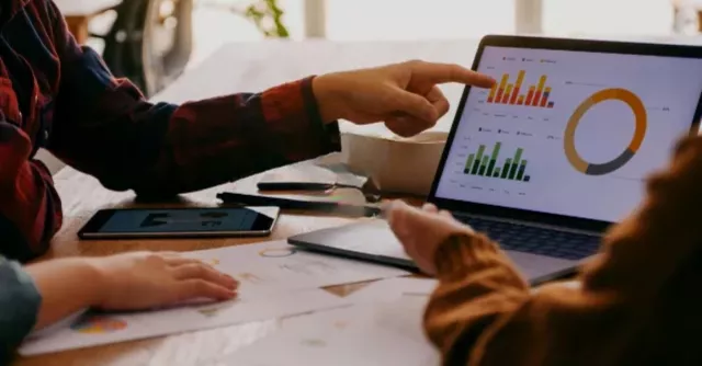 Hands pointing to data on a computer