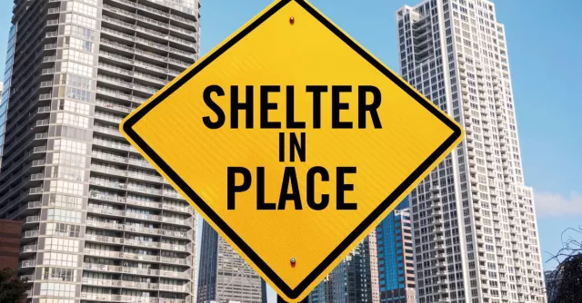 shelter in place sign in front of buildings