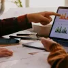 Hands pointing to data on a computer